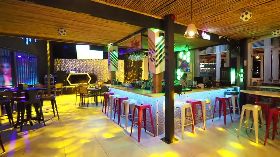 La barra del salón principal de Tuani's, con las pantallas encendidas
